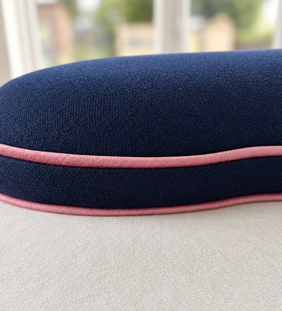 Close-up of the navy upholstery and neatly finished blush piping